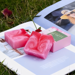 Natural Rose Care Soap bar featuring vibrant pink swirls, highlighting its nourishing ingredients of rose petals and essential oils.