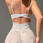 Back view of a white lace mini nightgown showcasing spaghetti straps and a fitted silhouette.